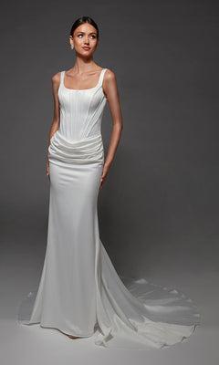 A woman wearing the Long Wedding Dress: Alyce 7171, a fitted white satin gown featuring a structured corset bodice, draped waist, square neckline, and a long train, stands against a dark gray background.