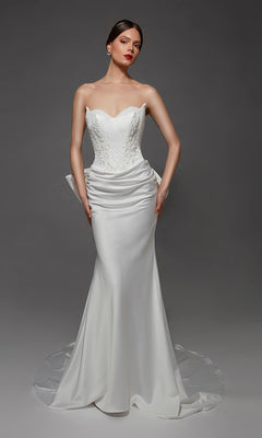 A woman modeling the Long Wedding Dress: Alyce 7177 in Diamond White, which features a strapless sweetheart neckline and intricate floral embroidery on the bodice, along with a draped, floor-length satin skirt, stands against a plain gray background.