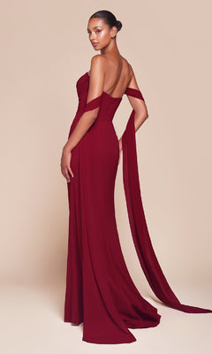 A woman stands against a beige background in the Multi-Way Long Chiffon Prom Dress: Ladivine 7433, featuring a floor-length, off-the-shoulder design with a fitted bodice and draped sleeves for an elegant, timeless look.