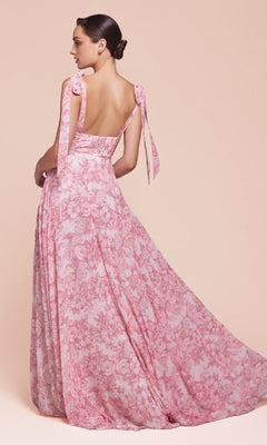 Model in the Ladivine 7442 Long Floral-Print A-Line Prom Dress with tied shoulder straps, standing against a light pink background and facing away.