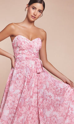 A woman poses against a neutral background wearing the CL7443 Strapless Long Print Prom Dress, featuring a sweetheart neckline and pink floral pattern.