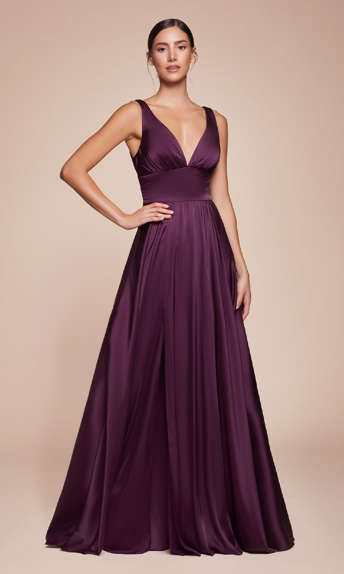 A woman stands against a plain beige background wearing the Ladivine 7469 Sleeveless Classic Long Prom Dress, featuring a deep v-neck and crafted from elegant purple satin.