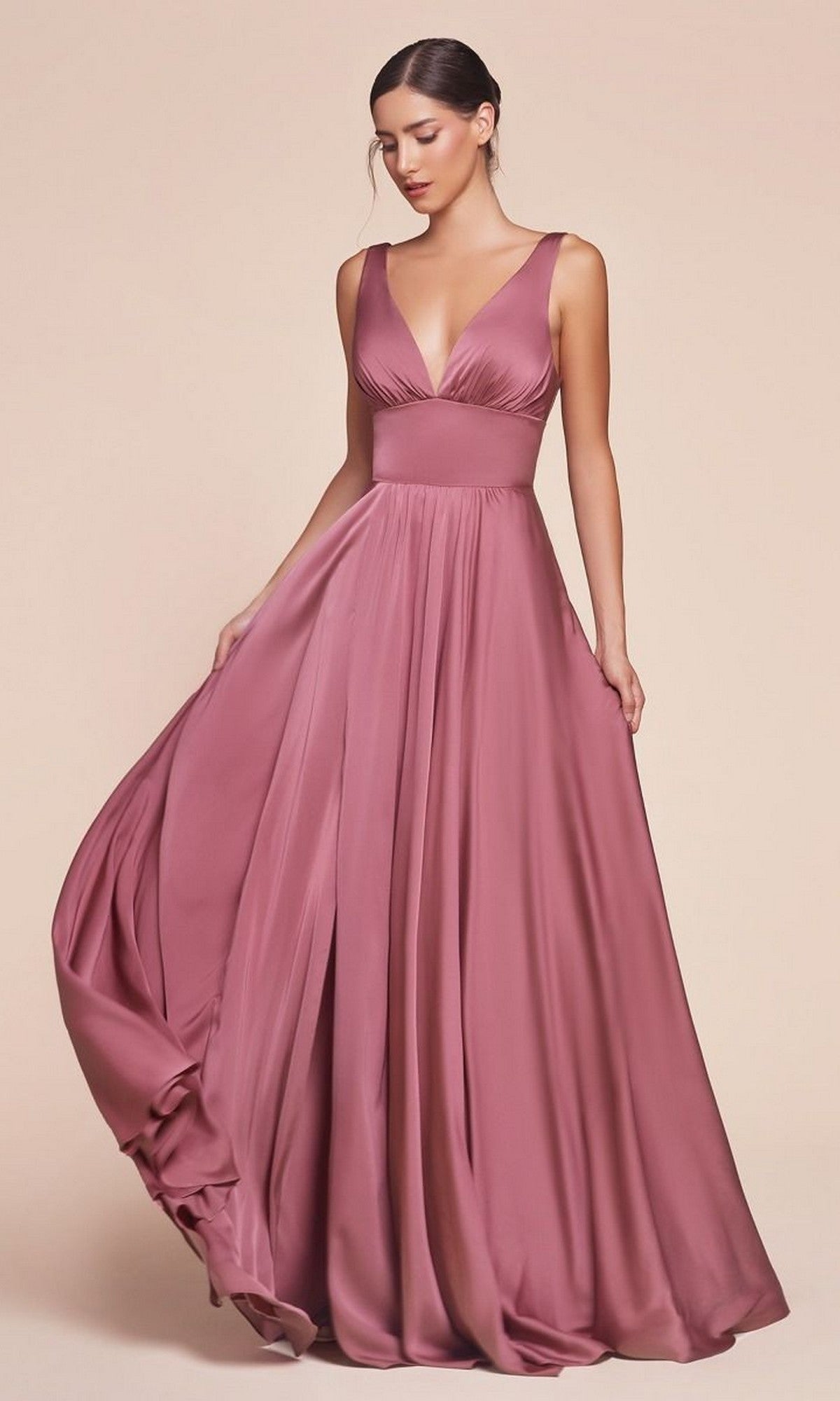 A woman in the Sleeveless Classic Long Prom Dress: Ladivine 7469—floor-length, mauve satin with a deep V-neckline—stands against a plain beige background.
