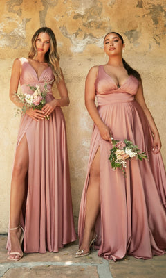 Two women in matching Empire-Waist Simple Satin Long A-Line Prom Dresses with thigh-high slits stand against a textured wall, each holding a small bouquet of flowers.