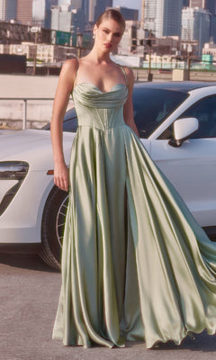 A woman wearing the Ladivine 7481 long satin A-line prom dress in pale green stands before a white car with a cityscape behind her.