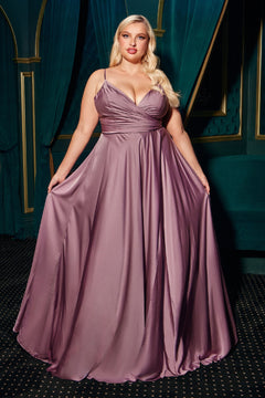 A woman stands before dark teal curtains, holding out the sides of her sleeveless mauve Plus-Size Long A-Line Prom Dress 7485C, a floor-length formal gown available for under $150.
