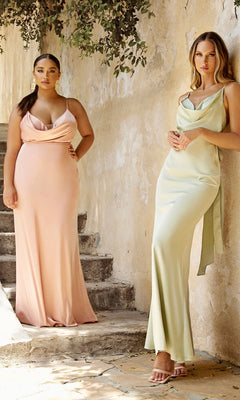 Two women stand outdoors against a beige wall with greenery above, wearing Tie-Back Long Prom Dress 7487 in blush pink and light green satin.
