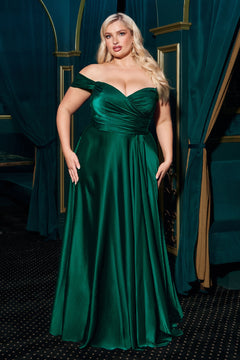 A woman models the Empire-Waist Plus-Size Long Prom Dress 7493C, a dark green, off-the-shoulder satin gown, standing indoors against an elegant teal backdrop with curtains.