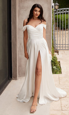 A woman poses outdoors in the affordable Ladivine 7493W Off-Shoulder White Prom Gown, featuring a thigh-high slit, near a building and metal fence.