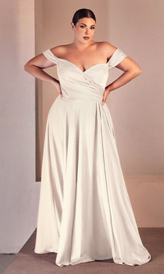 A woman stands indoors wearing the Ladivine 7493WC, a long plus-size off-white wedding dress featuring an off-the-shoulder neckline, fitted bodice, and flowing skirt.