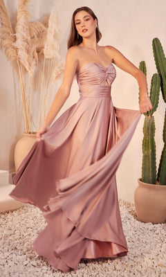 A woman poses indoors beside pampas grass and a cactus, gracefully holding out one side of her mauve Strapless Sweetheart Long A-Line Prom Dress 7496.