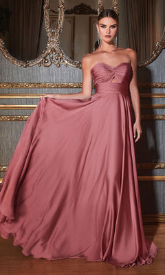 A woman poses indoors in the Strapless Sweetheart Long A-Line Prom Dress 7496, holding out part of the mauve skirt with one hand; ornate decor and a large mirror are in the background.