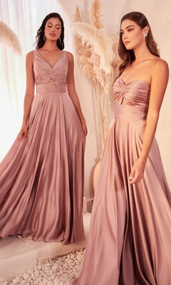 Two women wear the Twist-Front Long A-Line Cut-Out Prom Dress 7497, featuring affordable, floor-length mauve satin with ruched bodices and sleeveless design, standing indoors by pampas grass decor.