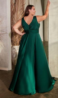 A woman stands with her back to the camera indoors, wearing the Twist-Front Long Plus-Size Prom Dress 7497C—a sleeveless, floor-length emerald green formal gown.