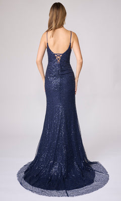 Woman in a navy blue sequin Nina Canacci 7656 long formal dress with spaghetti straps and lace-up back shimmers in this form-fitting look as she stands facing away from the camera.