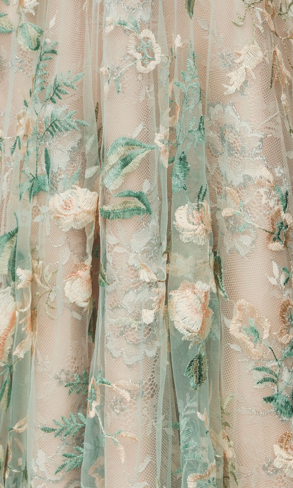 Close-up of sheer fabric from the Long Cream Floral Prom Dress (Mac Duggal 79329) features pastel green, peach, and cream embroidery—layered and textured in Mac Duggal’s signature style.
