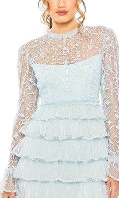 A woman showcases the Long Formal Dress 8003 by Mac Duggal—light blue lace with sheer embroidered sleeves and bodice, plus a layered ruffle skirt, shown from shoulders to thighs.