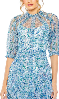 A woman wears the Midi Wedding Guest Dress 8011 by Mac Duggal, featuring blue and white florals, sheer puff sleeves, and textured fabric, shown from shoulders to mid-thigh against a white background.