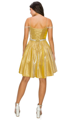 A woman stands with her back to the camera, wearing the Beaded Cold-Shoulder Short Homecoming Dress 8014J in gold metallic shimmer with decorative straps and silver heels—a chic choice for any semi-formal event.
