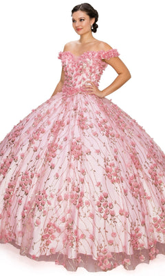 A woman stands against a white background wearing the Quinceanera Ball Gown 8021J, featuring a voluminous pink off-the-shoulder design with a lace-up corset bodice and 3D floral details.
