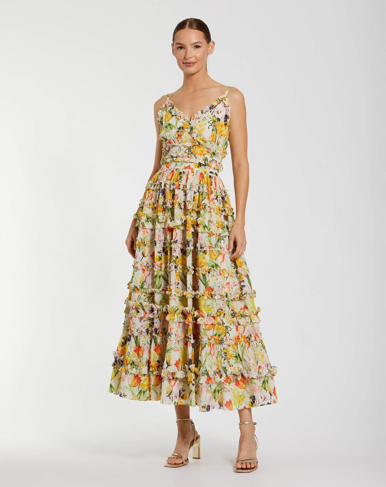 A woman models the Mac Duggal 8026 Midi Print Wedding Guest Dress—sleeveless, ankle-length, with floral print and ruffle details—styled with neutral heels, ideal for an elegant wedding guest look against a white background.