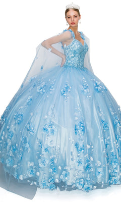 A woman in the Quinceanera Ball Gown 8030J—light blue with 3D floral embellishments, a sheer cape, and a tiara—stands against a white background.