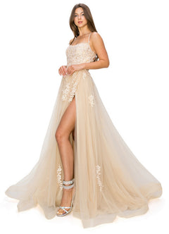 A woman in the Floral-Embroidered Long Tulle Prom Dress 8031J with a thigh-high slit and silver high-heeled sandals stands against a white background.