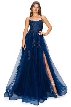 A woman wearing the Floral-Embroidered Long Tulle Prom Dress 8031J, a navy blue formal gown with floral lace details, spaghetti straps, and a thigh-high slit, paired with silver high-heeled sandals.
