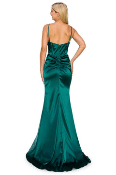A woman stands facing away, wearing the Sheer Side-Slit Long Corset Prom Dress 8037J in emerald green satin, featuring thin straps and a ruched back.