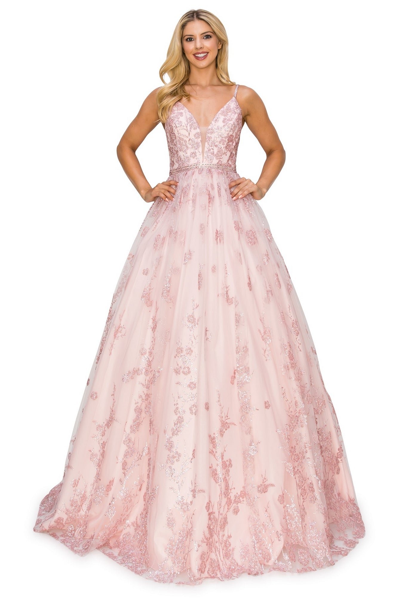 A woman wearing the Corset-Back Long Glitter Prom Ball Gown 8039J, a sleeveless, floor-length pink A-line dress with floral embroidery and a deep V-neckline, stands smiling with hands on hips.