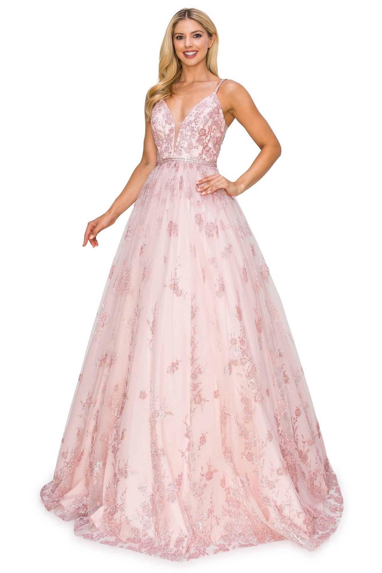 A woman stands and smiles in the Corset-Back Long Glitter Prom Ball Gown 8039J, a sleeveless, floor-length pink dress with floral glitter, lace accents, and a deep V neckline.