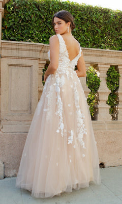 A woman in the Cinderella Couture 8040J long formal dress, featuring sleeveless styling and 3D floral lace appliques, stands outdoors by a stone railing and manicured greenery, turned slightly away from the camera.