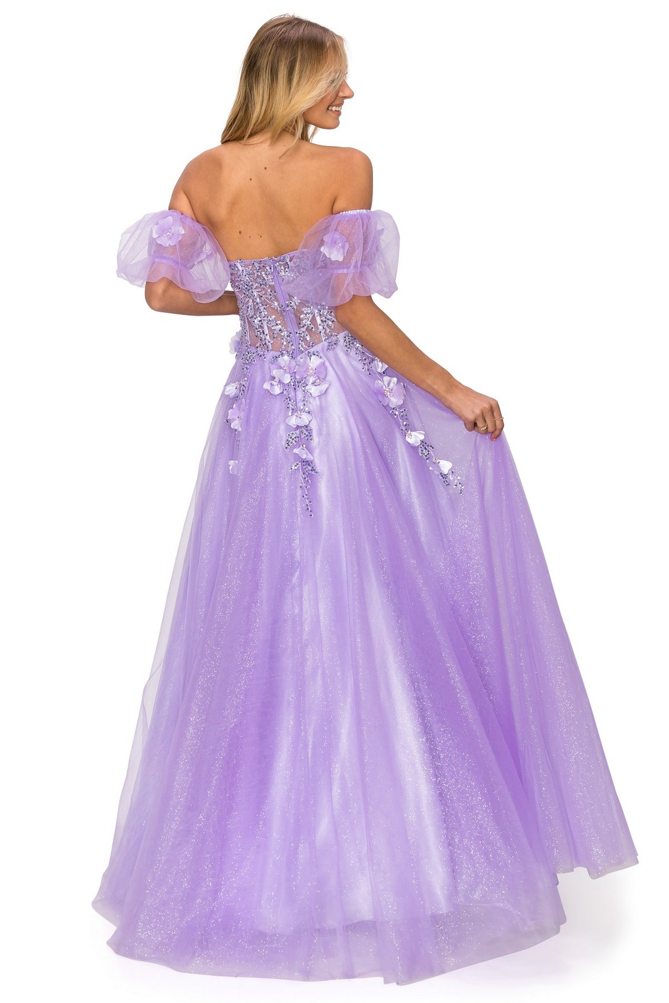 A woman in the Puff-Sleeve Long Sweetheart Prom Ball Gown 8042J stands facing away, showcasing shimmering lavender fabric with intricate lace and floral details on the back of her elegant formal dress.