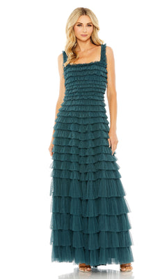 A woman wears the Teal Long Ruffled Prom Dress: Mac Duggal 8046, a sleeveless, floor-length gown featuring layered ruffles and a square neckline, paired with open-toed heels.