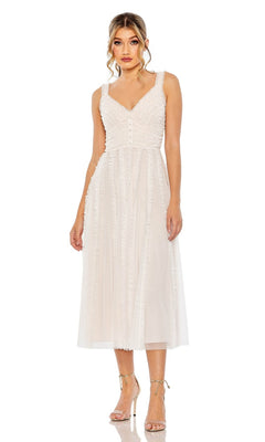 A woman stands wearing the Mac Duggal 8056 Ruffled Midi Wedding Guest Dress—a sleeveless, light-colored, knee-length party dress with a textured bodice and sheer overlay—perfectly paired with strappy high-heeled sandals.