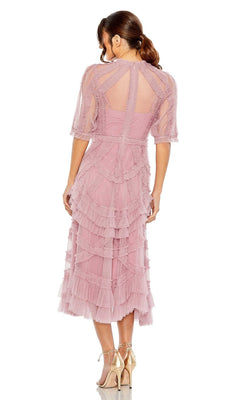 A woman faces away in the Mac Duggal 8058 Ruffled Midi Wedding-Guest Dress—light pink, tiered with ruffles, sheer short sleeves—paired with nude high heels, set against a white background.