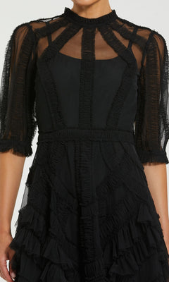 A person wearing the Mac Duggal 8058 Ruffled Midi Wedding-Guest Dress, featuring sheer paneling, ruffled elbow-length sleeves, and a classic black midi design.