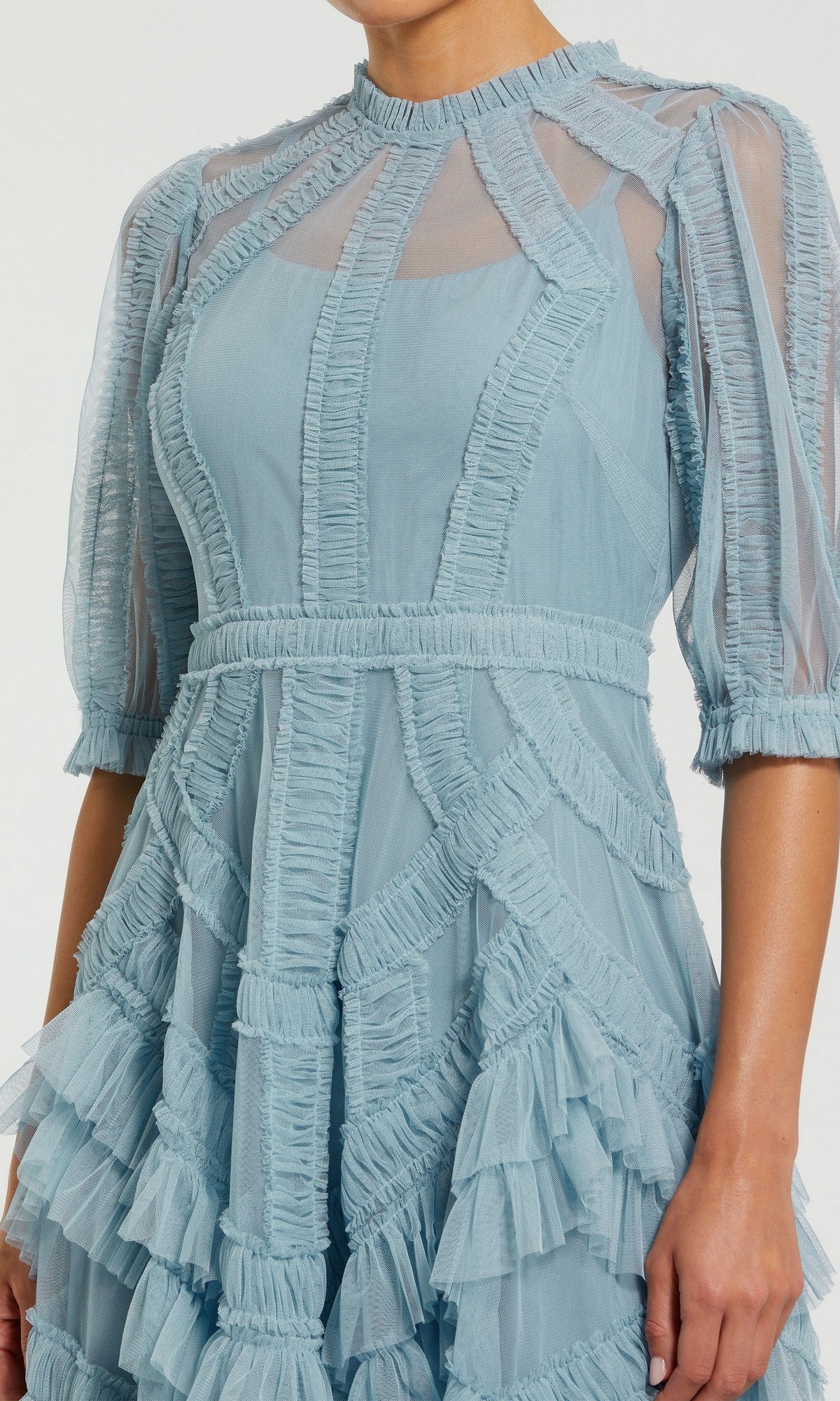 Wearing the Mac Duggal 8058 Ruffled Midi Wedding-Guest Dress—a light blue, modest tea-length style with sheer fabric, ruffled half sleeves, textured detailing, and layered accents—perfect for any wedding guest.