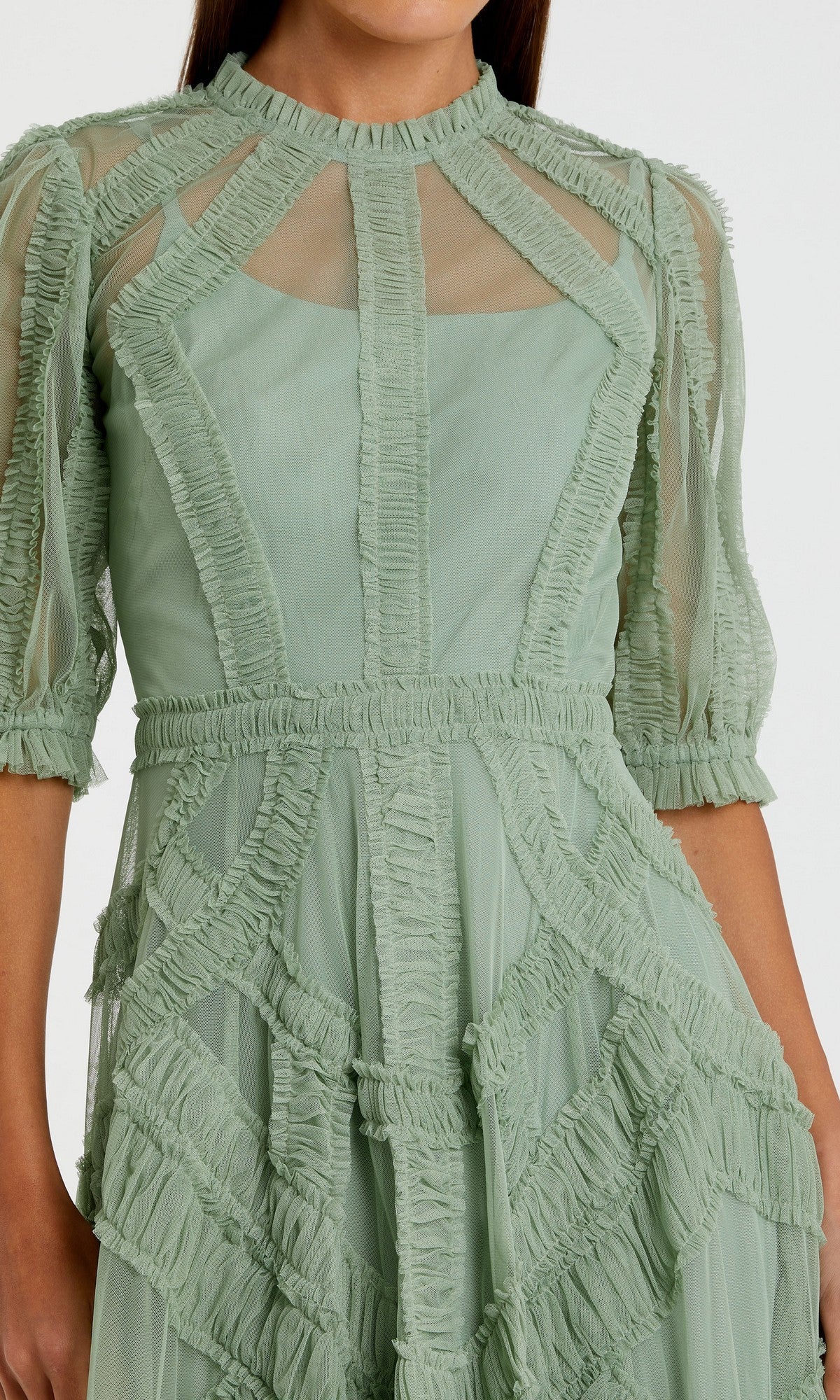 Model wearing the Mac Duggal 8058 Ruffled Midi Wedding-Guest Dress in light green, featuring sheer panels, decorative ruffle details, half-length ruffled sleeves, and a high neckline; shown from shoulders to knees.
