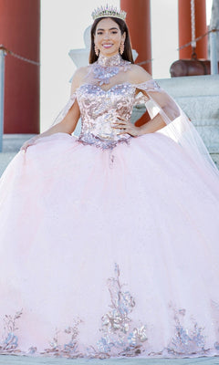 A young woman poses outdoors in front of stone steps wearing the Quinceanera Ball Gown 8064J, featuring sparkling pink lace embroidery with floral details, an off-the-shoulder design, and detachable sleeves, accessorized with a tiara.