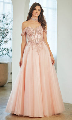 A woman stands indoors in soft lighting, wearing the Amelia Couture 8065 long prom dress—light pink, off-the-shoulder with floral embroidery, a corset bodice, and a matching choker.