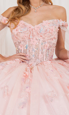 A woman wears the Cinderella Couture 8075J quinceanera dress in pink with floral embroidery, sequins, tulle details, a jeweled necklace, and a detachable sheer cape for added elegance.