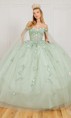 A woman stands indoors wearing the Cinderella Couture 8075J, a sparkling pale green off-the-shoulder quinceanera dress with 3D floral appliques and a gold crown.