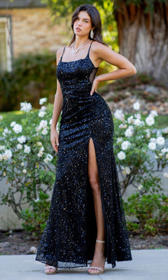 A woman stands outdoors among greenery and white flowers, wearing the Cinderella Couture 8081J backless sequin prom dress—sleeveless, black, with a thigh-high slit.