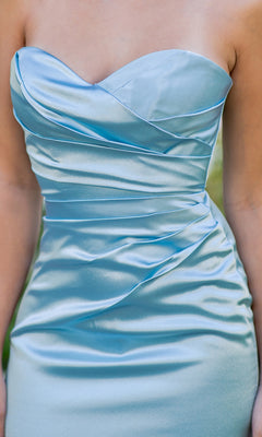 A woman wearing the Cinderella Couture 8083J Satin Mermaid Prom Dress, strapless in light blue with pleated and ruched detailing for an elegant look.
