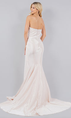 A blonde woman poses with her back to the camera in the Cinderella Couture 8083J, a strapless, floor-length light pink satin mermaid prom dress with a slight train, set against a gray background.