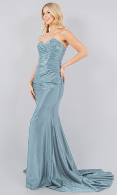 A woman wears the Satin Mermaid Prom Dress: Cinderella Couture 8083J in metallic blue, featuring a strapless sweetheart neckline, fitted silhouette, and long train, standing against a plain light gray background.