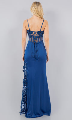 A woman faces away against a plain gray background, wearing the Long Corset Prom Dress: Cinderella Couture 8085J— a sleeveless, floor-length blue gown with a lace-up back and delicate beaded embroidery.