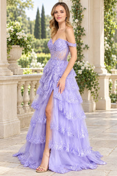 A model wears an Amelia Couture 8085 lilac off-the-shoulder prom ball gown featuring a corset bodice, a sequined tiered skirt, and a high leg slit.