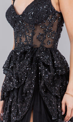 A person wearing the Ruffled Tiered Prom Dress: Cinderella Couture 8093J, a black, sleeveless gown featuring sheer panels and intricate sequin embellishments.